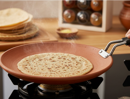 Clay Tawa With Handle for Roti - 9 inch cooking roti on a gas stove with steam rising.